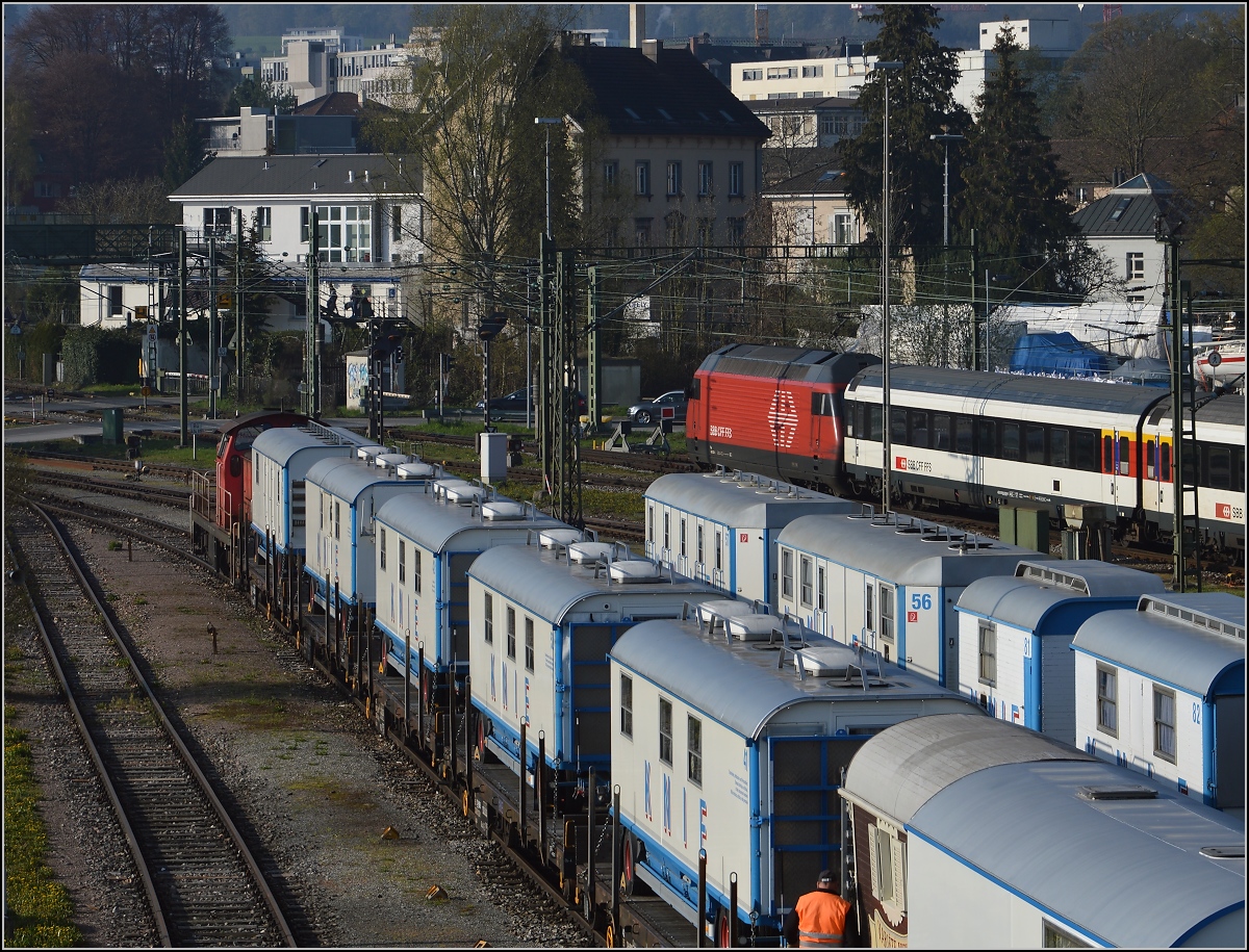 Abladen des Zirkus Knie in Konstanz. Ein weiterer Teil des Zuges wird an die Laderampe bugsiert, während dahinter ein IR richtung Zürich ausfährt. April 2016.