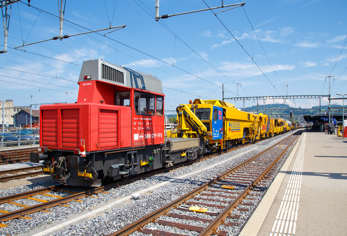 
Am Zugschluss der Bautraktor bzw. das Baudienstfahrzeug Tm 234 136-0 (Tm 98 85 5 234 136-0 CH-SBBI) der SBB Infrastruktur am 18.05.2018 beim Signalhalt im Bahnhof Yverdon-les-Bains (VD). 
Weitere folgende Wagen und Fahrzeuge:
Die Scheuchzer BNA 663, eine Matisa B 66 U Universalstopfmaschine mit Planieranhänger, CH-SCHEU 99 85 92 22 003-7 (SBB Nr.: VTmaas 40 85 95 81 037-1):
Kranzug der Vanomag AG, bestehend aus dem Schutzwagen (Gattung Res 072-6) 31 85 3936 019-4 CH-ORME, dem 100 t GOTTWALD Gleisbauschienenkran GS 80.08 T (Kran V), 99 85 9219 025-5 CH-VMG VTmaass, ex VTmaass 80 85 95 81 404-3 und dem Gegengewichtwagen (Gattung Res) 37 80 3940 044-5 D-ORME;
Dem Zementsilowagen 33 85 9326 254-0 CH-VICEM, der Gattung Uacns, der Ciments Vigier SA;
Sowie weiterer Güterwagen gezogen von einer Re 4/4 II.