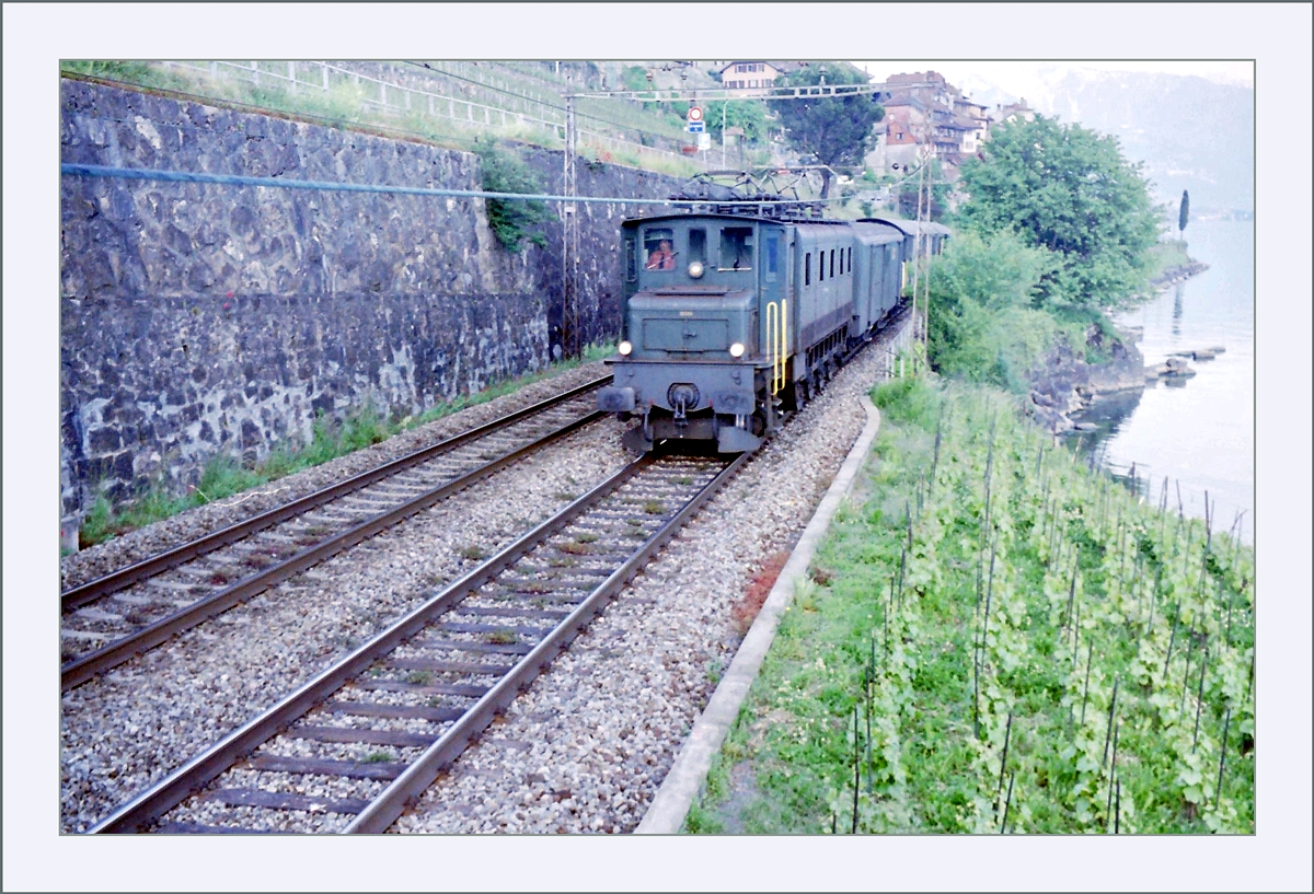 An etwa derselben Stelle zeigt sich eine Ae 4/7 mit einem Postzug auf dem Weg nach Vevey. 

Analogbild vom Mai 1995
