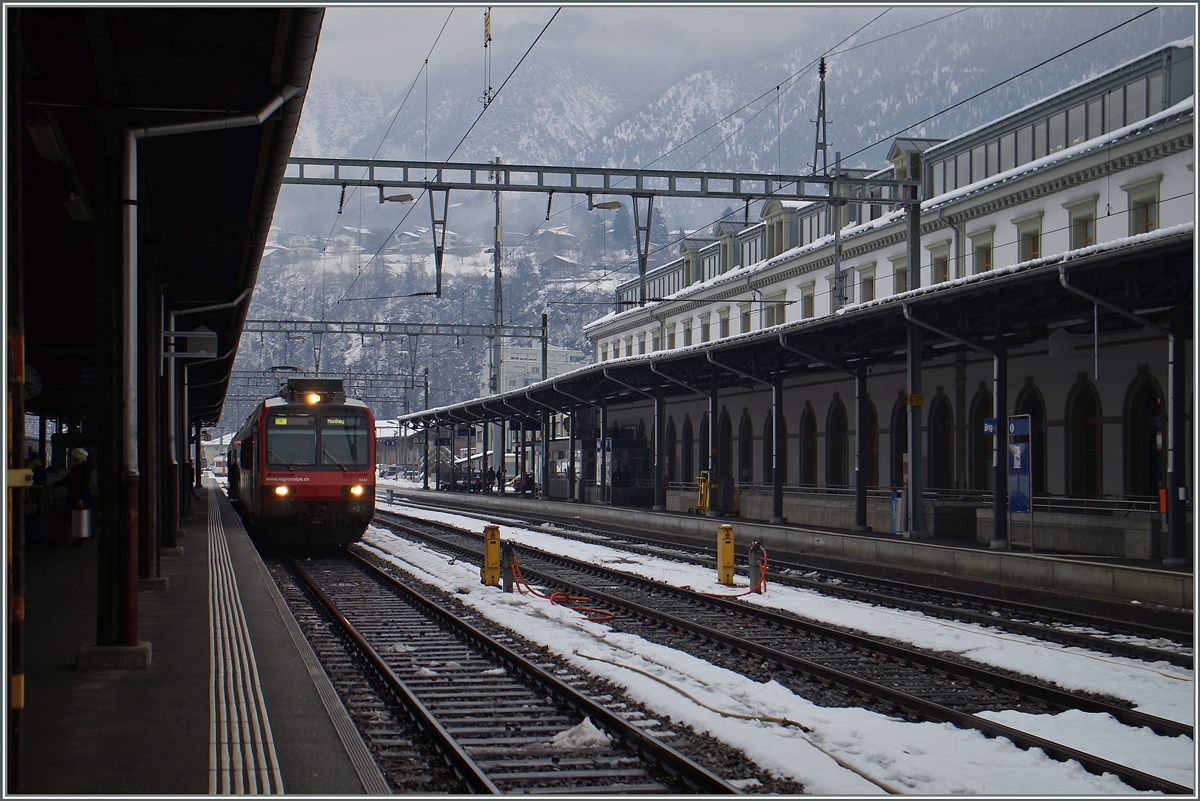 Auf Gleis 3 wartet eine  Walliser Domino  auf die Abfahrt nach Monthey, recht im Bild ein Teil des imposanten Bahnhofgebebäudes von Brig.
8. Jan. 2016
