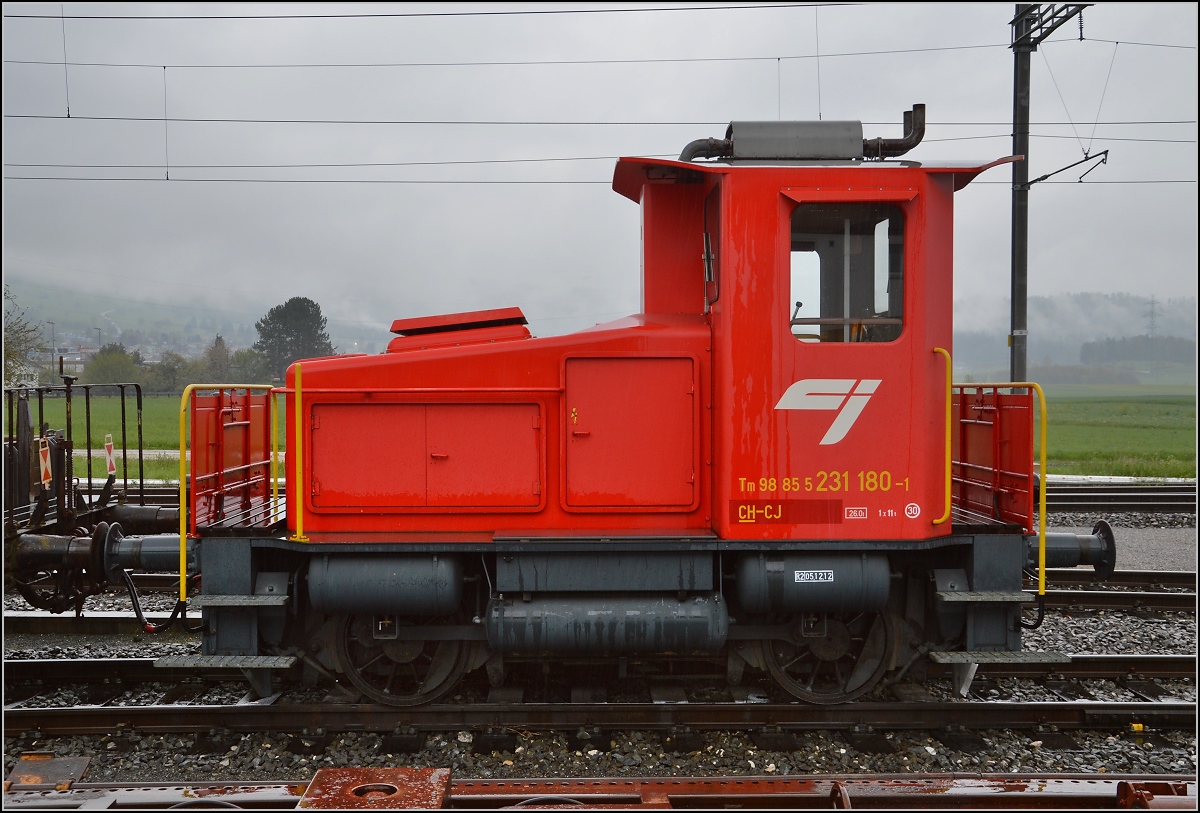 Chemins de fer de Jura (CJ). Tm<sup>III</sup> 180 der CJ steht arbeitsbereit an der Rollschemelanlage in Glovelier. April 2016.

Eckdaten des Tm<sup>III</sup>:
Baujahr 1962
Länge 6,42 m
Gewicht 27 t
Leistung 147 kW 
Höchstgeschwindigkeit 30 km/h