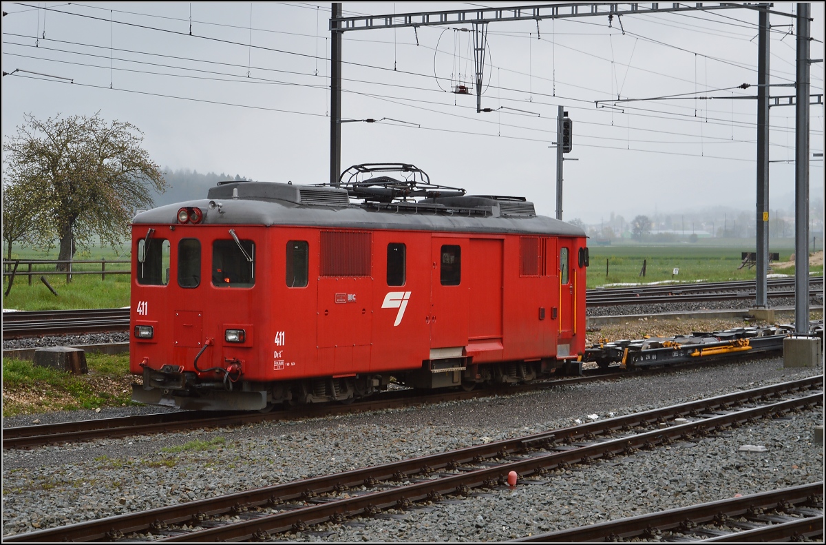 Chemins de fer de Jura (CJ). De 4/4 411 der CJ steht arbeitsbereit an der Rollschemelanlage in Glovelier. April 2016.