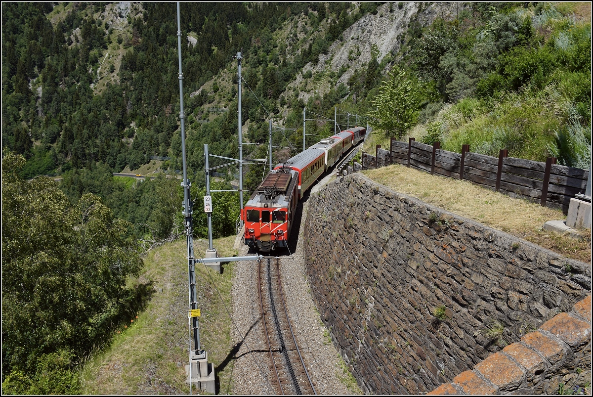Deh II 96 Münster in der Kreiskehre von Grengiols mit einem Zug Richtung Andermatt. Juni 2018.