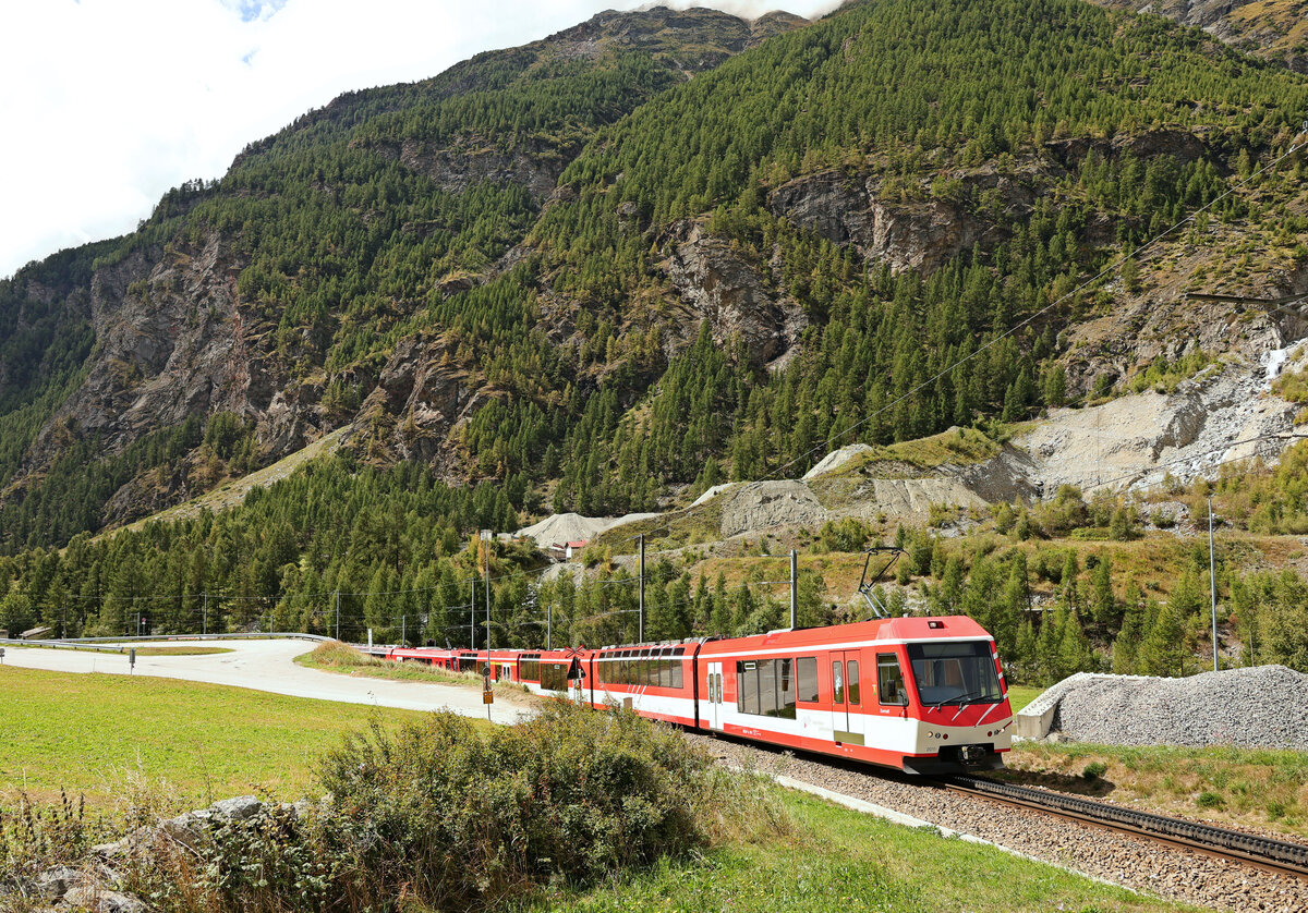 Der Bergsturz von Randa: Ein Zug hat auf der Fahrt talabwärts Randa gerade verlassen, muss aber erst einmal die Umfahrungsstrecke hinaufklettern (und dann wieder hinunter). Der Zug wird geführt von Triebwagenzug ABDeh 4/10 2011. 30.August 2025  