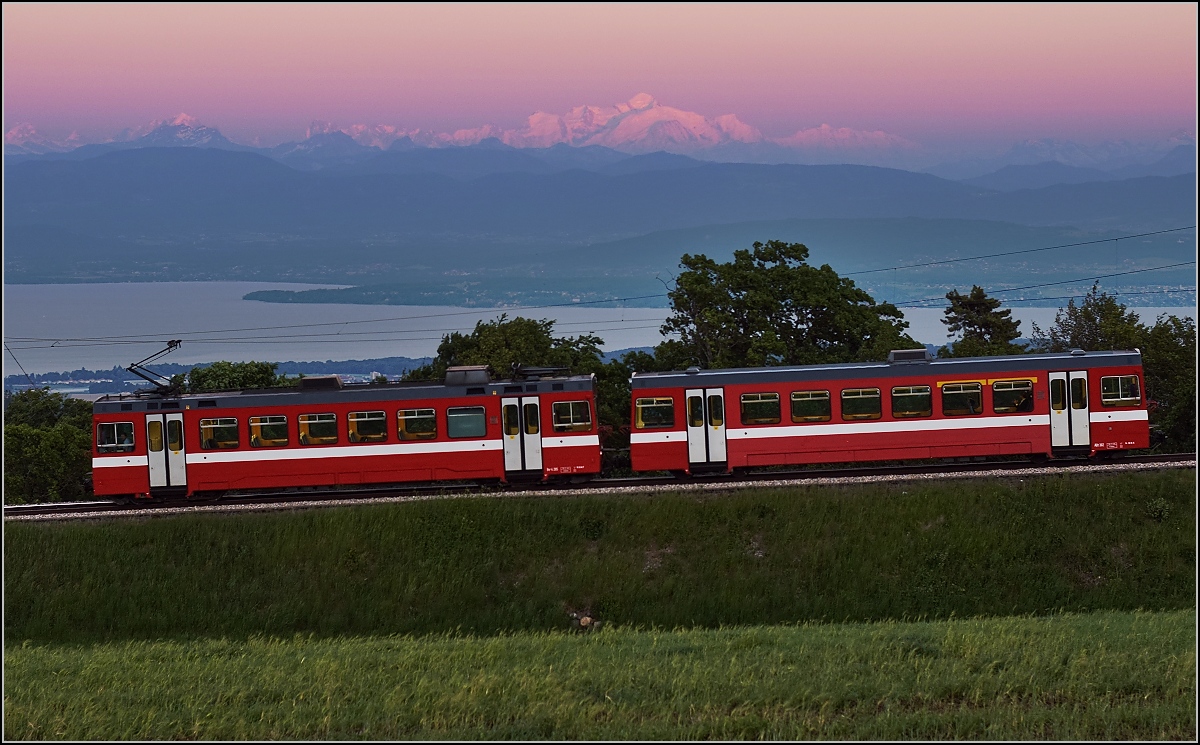 Der mittlerweile 32-j�hrige Be 4/4 205 f�hrt mit Beiwagen von Arzier nach Bassins w�hrend der Mont Blanc im Hintergrund in den wunderbarsten Abendfarben leuchtet. Leider hatte der Zug 7 Minuten Versp�tung und der Zauber des Mont Blanc war schon halb vergangen. Eine sehr imposante Strecke von Nyon nach St. Cergue/La Cure, die einst sogar auf franz�sischer Seite bis ins Bienntal weiterf�hrte. Heute ist ebenso wie in St. Gingolph der letzte Mast auf der Grenze. Arzier, Mai 2017.