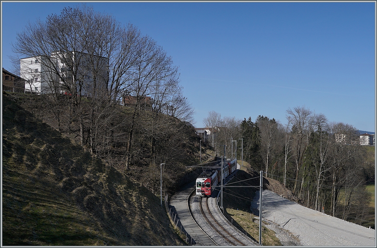 Der TPF Be 4/4 124 mit dem Bt 224 und dem ABt 223 sind als S60 14960 von Bulle auf dem Weg nach Broc-Fabrique und an dieser Stelle schon fast am Ziel der Reise. 
Die Schmalspurzüge werden bald durch Normalspurzüge aus Bern oder Fribourg abgelöst, rechts im Bild sind schon Geländearbeiten für die Umspurarbeiten erkennbar. 

2. März 2021