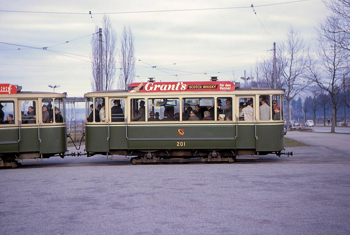 Die alten Berner Zweiachs-Anhänger: 1904 erhielt Bern eine Gruppe von Sommerwägelchen mit offener Seite, 101-108. Während der 1920er Jahre studierte man Möglichkeiten, diese für den modernen Betrieb anzupassen, indem sie neue Wagenkasten, zunächst aber keine Verlängerung erhielten. 108 bekam 1921 einen geschlossenen Kasten mit geschlossenen Endplatformen ohne Seitentüren (neu 208). 101 erhielt 1922 versuchsweise einen Kasten mit Mitteleinstieg (neu 201). 103 wurde dann 1929 deutlich verlängert, erhielt aber einen eckigen Kasten ähnlich wie die alten Motorwagen (neu 203). All das befriedigte nicht, und so wurden die restlichen Wagen mit einem Standard-Zweichsanhänger-Wagenkasten praktisch völlig neu aufgebaut; 203 blieb dabei etwas kürzer und wurde nur als Stosszeiten-Anhänger an Regelkursen der Linie 5 verwendet. Die Umbauten (praktisch Neubauten?) mit Standard-Wagenkasten erfolgten 1931 (202/204), 1932 (205/206), 1933 (207, dazu kompletter Neuaufbau von 201 und 208). Im Bild der schwer beladene Wagen 201 in der alten Schlaufe Wankdorf, 20.Februar 1966. Wagen 201 wurde 1968 abgebrochen.    