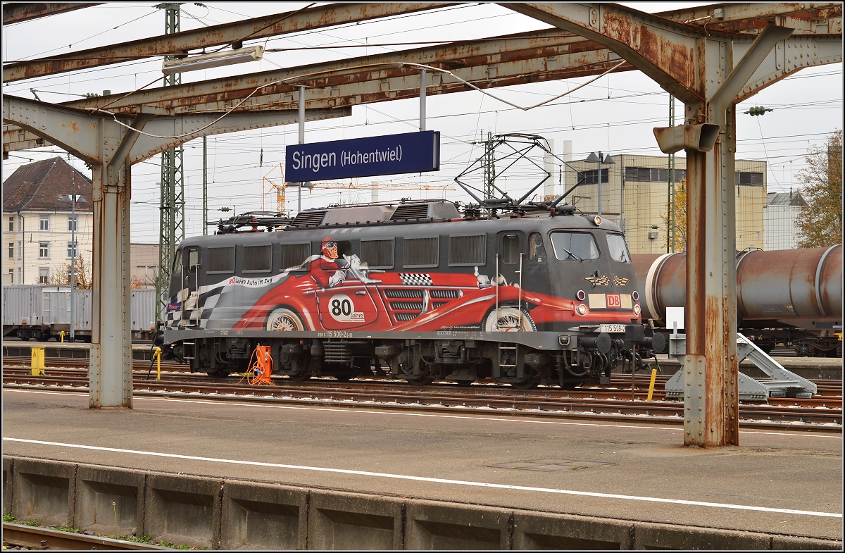 Die exotische 115 509-2 mit der Autozugwerbung in Diensten der Gäubahn-ICs wartet in Singen auf den nächsten Einsatz. Oktober 2015.