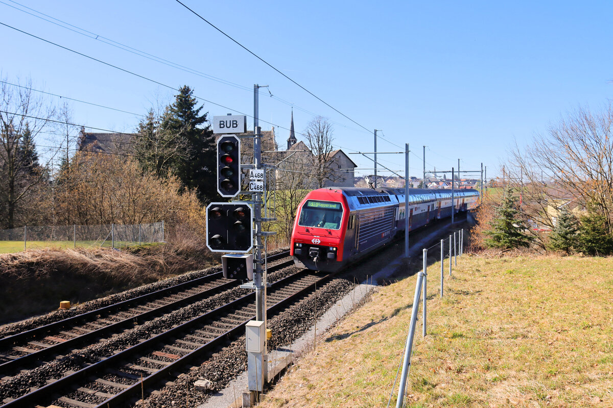 Die Strecke Uster - Wetzikon - Rüti ZH - Rapperswil: Lok 450 062 bringt Ihre S15 am Ritterhaus von Bubikon vorbei in Richtung Rüti ZH und Rapperswil. 5.März 2025 