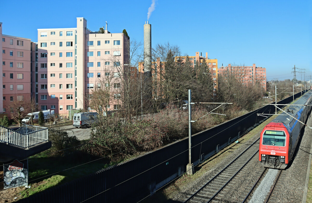 Die Strecke Uster - Wetzikon - Rüti ZH - Rapperswil: Einfahrt nach Nänikon-Greifensee, wo immer mehr die Atmosphäre eines zürcher Vororts herrscht. Der Zug ist eine S9 von Schaffhausen über Zürich nach Uster. Lok 450 043. 5.März 2025 