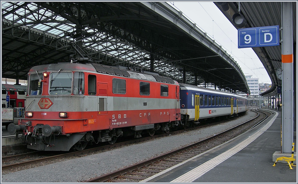 Die Zeit der Re 4/4 II 11109 in der Westschweiz, insbesondere auf der Strecke Genève - Brig neigt sich dem Ende entegegen, da die Strecke Lauanne - Villeneve ab dem 23 April 2017 auf ETCS umgestellt wird.
Auf dem Bild ist die Re 4/4 II 11109 mit eine Dispozug Brig - Genève beim Halt in Lausanne zu sehen. 
9. Jan. 2017