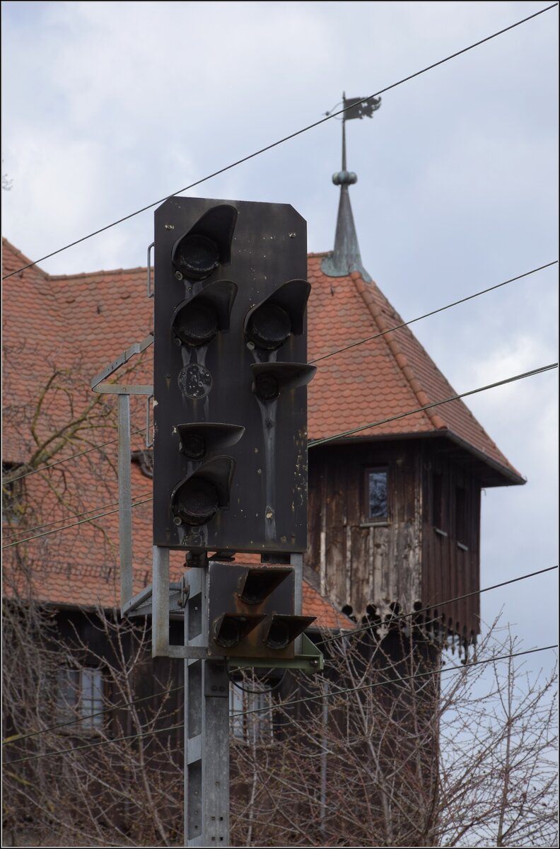 Dieser Tage streiken mal nicht Fahrzeuge, Weichen oder Signale im großen Kanton, sondern die Mitarbeiter.

Und weniger wehrhafte Signale werden bestreikt, die irgenwie gleich alt aussehen, wie das Kaufhaus dahinter aus dem Jahr 1188. Dunkle Signale sieht man jedenfalls nicht alle Tage. Bahnhof Konstanz Richtung Norden. März 2023.