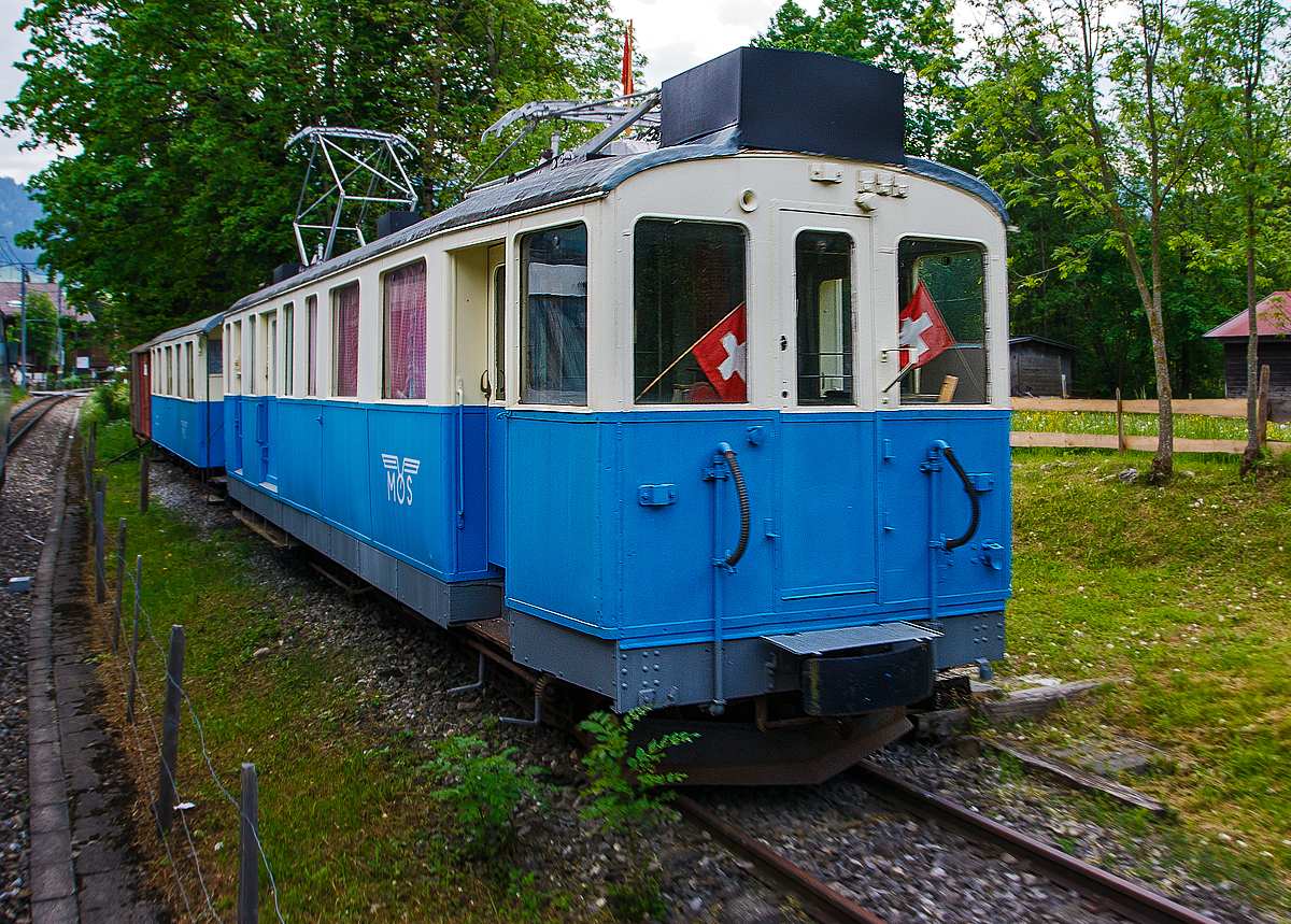 Ehemaliger MOB Triebzug De 4/4 26 mit B4 61 am 28.05.2012 in Saanen, aufgenommen aus fahrendem Zug. Der Zug ist seit 1994  abgestellt als der Vereinslokal odellbahngruppe Obersimmental-Saanenland (MOS). Der Triebwagen wurde 1912 SIG/Alioth als BFZe 4/4 26 gebaut, 1956 umgezeichnet in AFZe 4/4 26; 1962 in ADZe 4/4 26; 1971 in BDe 4/4 26; 1991 in De 4/4 26.

