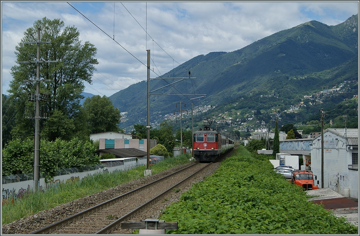 Eine SBB Re 4/4 II erreicht mit ihrem Gotthard IR von Locarno kommend Riazzino.
21. Juni 2016