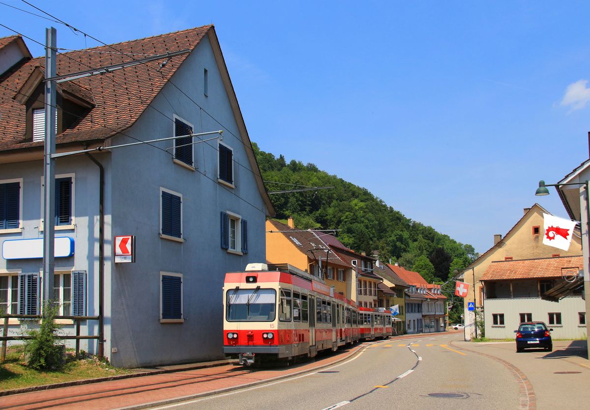 Es ist heute fast in Vergessenheit geraten, dass der Obere Hauenstein einst einer der wichtigsten Pässe der Schweiz war und Basel, d.h. ganz Nordeuropa, mit dem schweizerischen Mittelland verband. Bis zum Bau der Autobahn in den 1960er Jahren quälten sich die Autos hier über den Pass. An diesem Ort ist die Heimat der extrem schmalspurigen Waldenburgerbahn (75 cm), die auf der Nordseite ein gutes Stück den Pass hinauffährt. Die Landschaft hat alle Merkmale einer wichtigen Pass-Strasse, wie im Bild in Oberdorf, wo der Dreiwagenzug mit Triebwagen 15 zu sehen ist. 22.Juni 2017    