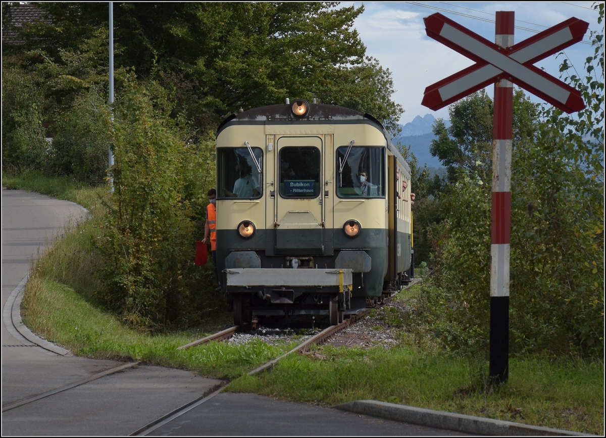Fahrtag Wolfhuuser Bahn.

Passage des Bahnübergangs am Ortsende Wolfhausen, vorne der ABt der IG Stammgleis Wolfhausen–Bubikon. Oktober 2021.