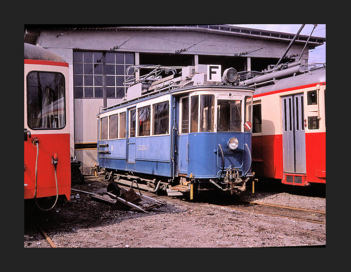 Forchbahn auf der Forch. Der alte Triebwagen BFe2/2 5, Baujahr 1912 vor dem Depot. Ich weiss nicht warum die beiden Fahrzeuge mitte und rechts schief stehen, der eine kippt nach rechts, der andere nach links. 25.März 1970 