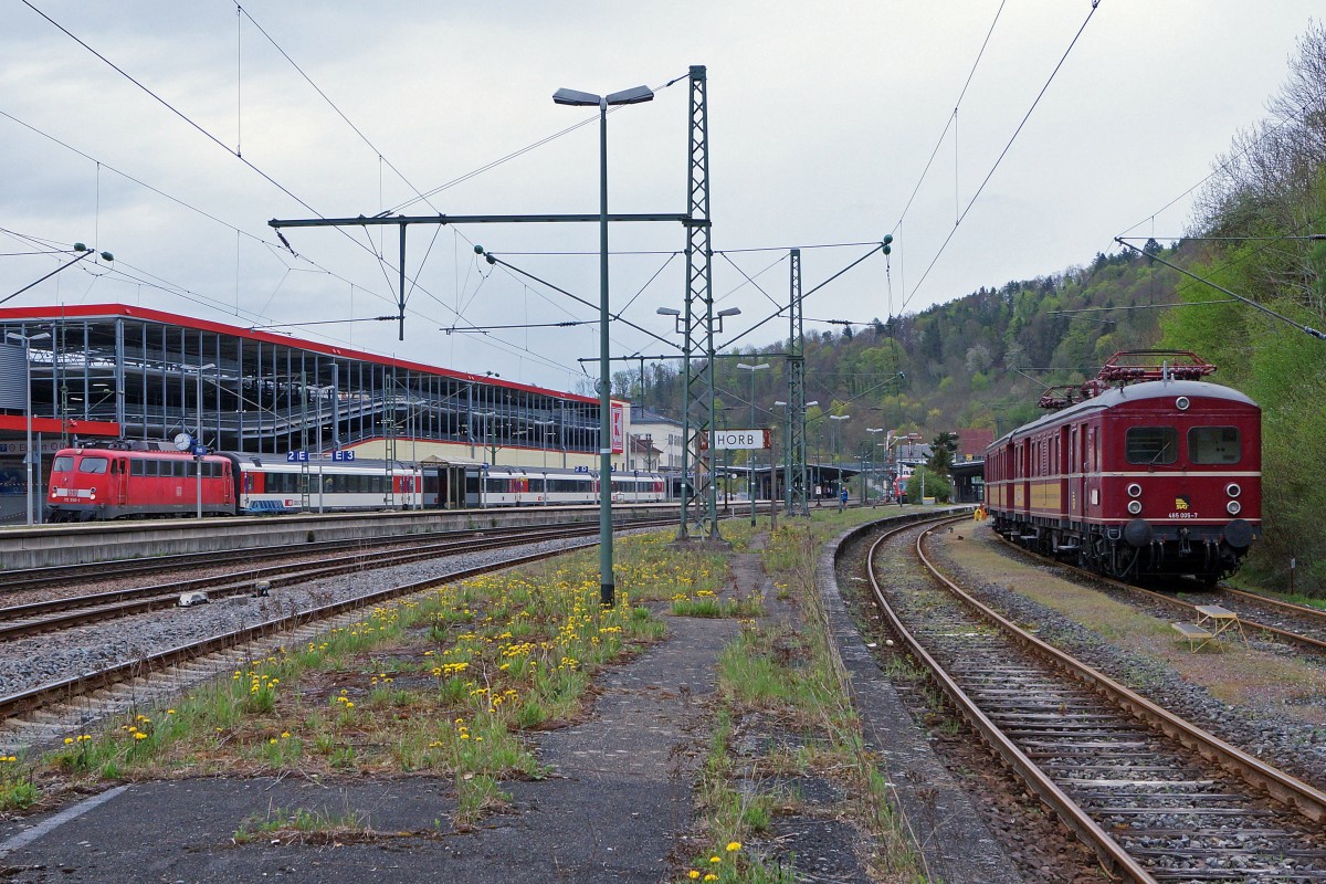 G�ubahn/SVG: 1. Abschiedsfahrt mit dem  Roten Heuler  ET 65 zur Eisenbahn-Erlebniswelt Horb am Neckar. Mit der Elektrifizierung der Hauptstrecke Stuttgart-Ulm im Jahre 1933 wurde auch in W�rtemberg eine neue Aera im Eisenbahnverkehr beschritten. F�r die Elektrifizierung der Vorortstrecken rund um Stuttgart entwickelte die Maschinenfabrik Esslingen (ME) einen neuartigen Trieb und Steuerwagen f�r die Deutsche Reichsbahngesellschaft (DRG). Zun�chst noch als Baureihe elT 12 und elS 22 bezeichnet, sp�ter dann als ET/ES 65 Baureihe 465 (865). Ueber 45 Jahre lang, von 1933 bis 1978, haben die  filigranen Schwaben  der Baureihe ET 65 Millionen von Fahrg�sten zur Arbeit, zur Schule und zu Freizeitaktivit�ten begleitet. Die  Roten Heuler  aus Esslingen haben verkehrsgeschichte geschrieben ! Erst 1978 wurde mit der Baureihe 420 ein Nachfolger ins Rennen geschickt und die ET 65 kamen in den verdienten Ruhestand. Das  Knacken und Zischen  der  Roten Heuler  ist aber bis heute unvergessen. 2006/2007 hat die SVG beide Fahrzeuge wieder in Betrieb genommen. Nach rund 8 Jahren im Sonderzugsverkehr f�hrt der ET 65 nun erneut in den Ruhestand, da eine weitere Hauptuntersuchung sehr teuer ist. Auf dem hintersten Geleise des Bahnhofs HORB warteten der 465 065-7 und der 865 611-8  am 25. April 2015 auf die abendliche R�ckfahrt nach Stuttgart Hbf. Der IC Stuttgart-Z�rich mit der 115 350-1 befindet sich bei einem Zwischenhalt auf der Fahrt nach Singen. Foto: Walter Ruetsch 