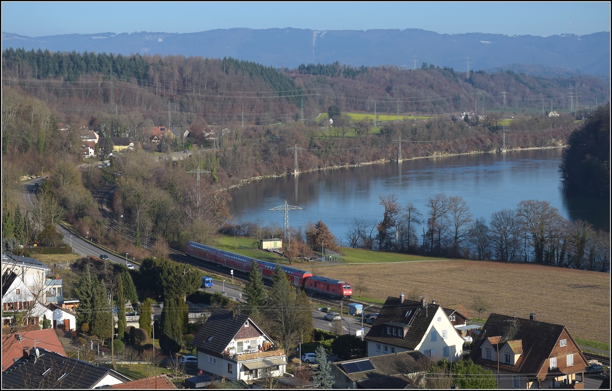 Godot-Express rechts des Hochrheins.

Eine BR 245 mit 3 Dostos. Karsau, Dezember 2021.

An jeder Station wird neuerdings erneut auf Godot gewartet. Er k�nnte ja noch kommen, auch wenn ihn bis heute niemand gesehen hat. Reisen im 612 war gestern, heute hei�t es durch die Landschaft bummeln. Beachtenswert noch: Entgegen der Versprechung leichter und schneller Einstieg f�hrt hier ein Hocheinstiegsdosto mit. Sehr geschickt bei den besseren Bordsteinen in den Bahnh�fen der Hochrheinbahn. So macht es keinen Unterschied zu den Einstiegszeiten der 612er.