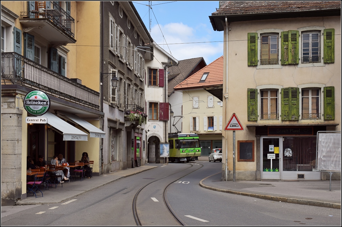 Ortsdurchfahrt in Bex. Es naht TPC-Triebwagen 92 der Bex–Villars-sur-Ollon–Bretaye-Bahn. Juli 2017.