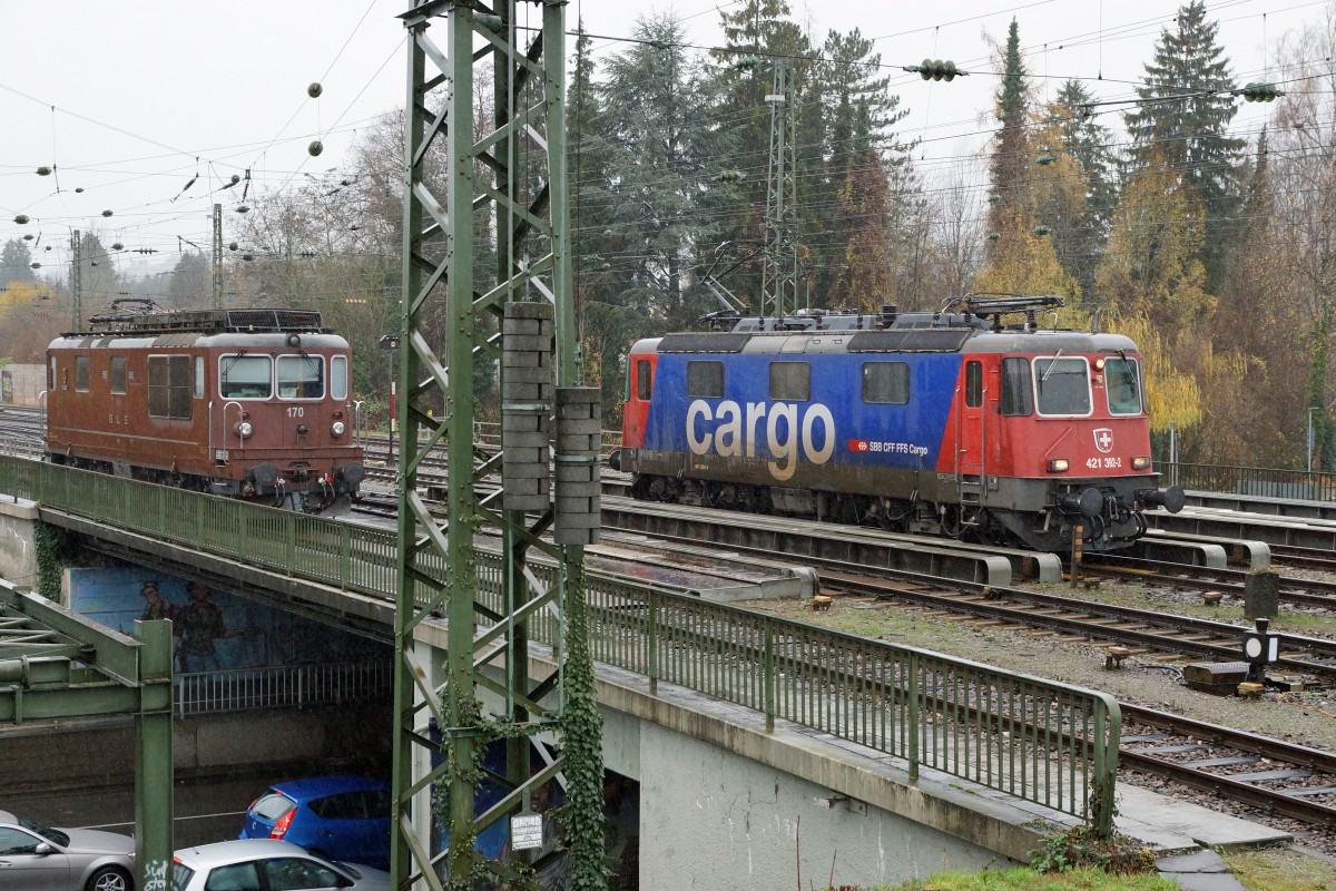 SBB/BLS/DB: Fotografieren in Singen am 20. November 2015 trotz starkem Wind und Dauerregen. An diesem Freitag konnten gleich zwei braune BLS Re 4/4 in Singen beobachtet werden. Begegnung zwischen der SBB Cargo Re 421 392-2 und der  BLS Re 4/4 170.
Foto: Walter Ruetsch