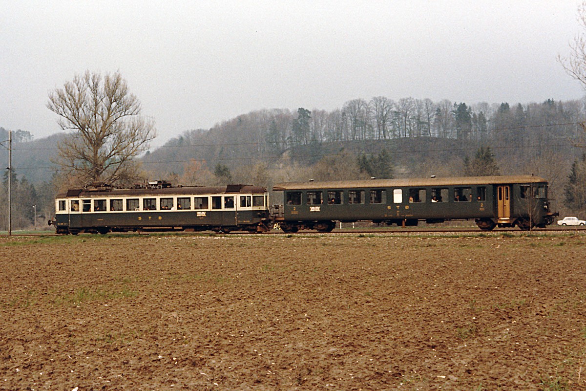 STB: Die Sensetalbahn hatte ihren Betrieb am 23.1.1904 aufgenommen. Die Streckenführung begann beim SBB-Bahnhof Flamatt und endete beim BN-Bahnhof Gümmenen. Am 23.5.1993 wurde der Streckenabschnitt Laupen-Gümmenen auf Busbetrieb umgestellt. Mit der Eröffnung der S-Bahn Bern wurde Laupen zu einem Endehalt einer S-Bahn. Die S-Bahn ab Freiburg endet bereits in Neuenegg. Zur Zeit befinden sich an der ehemaligen STB Strecke keine SBB Cargo Kunden mehr. Im Jahre 1986 wurden in Neuenegg die Güterwagen von einer SBB Ae 6/6 abgeholt. Ab dem Jahre 1987 hatte diese Aufgabe eine BLS Ae 6/8 übernommen. STB Pendelzug bestehend aus einem Be 4/4 106/107 ex SOB ABe 4/4 und dem Bti 201 ex BN Personenwagen auf dem Streckenabschnitt Laupen-Gümmenen im Jahre 1985.
Foto: Walter Ruetsch  