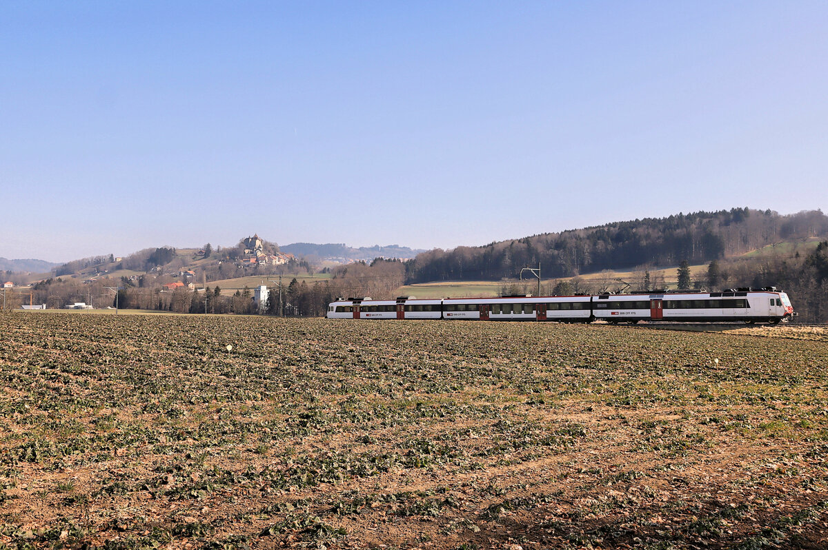 Unterwegs ins Broyetal: Einfahrt eines Domino-Zugs (ABt 39-43 802 - B 29-43 118 - RBDe 560 218) in Ecublens-Rue. Hinten ist die auch von der Hauptstrecke Fribourg - Lausanne gut sichtbare Burg Château de Rue zu sehen, die 17. bis 18.Jahrhundert ihre heutige Gestalt annahm und in dieser Zeit den Freiburger Vögten und Präfekten diente. 10.März 2022  