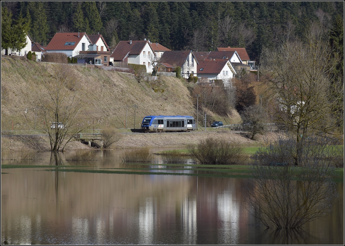 X 73754 bei der Einfahrt nach Morteau. Im Vordergrund der über die Ufer getretene Doubs. April 2018.