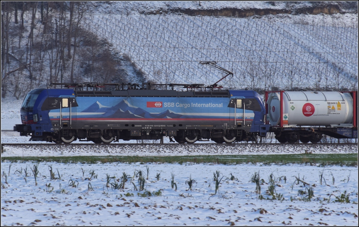 Zwischen Belchensystem und Blauendreieck. 

193 523 der SBB zieht ihren Zug von Basel gen Norden. Buggingen, Februar 2021.