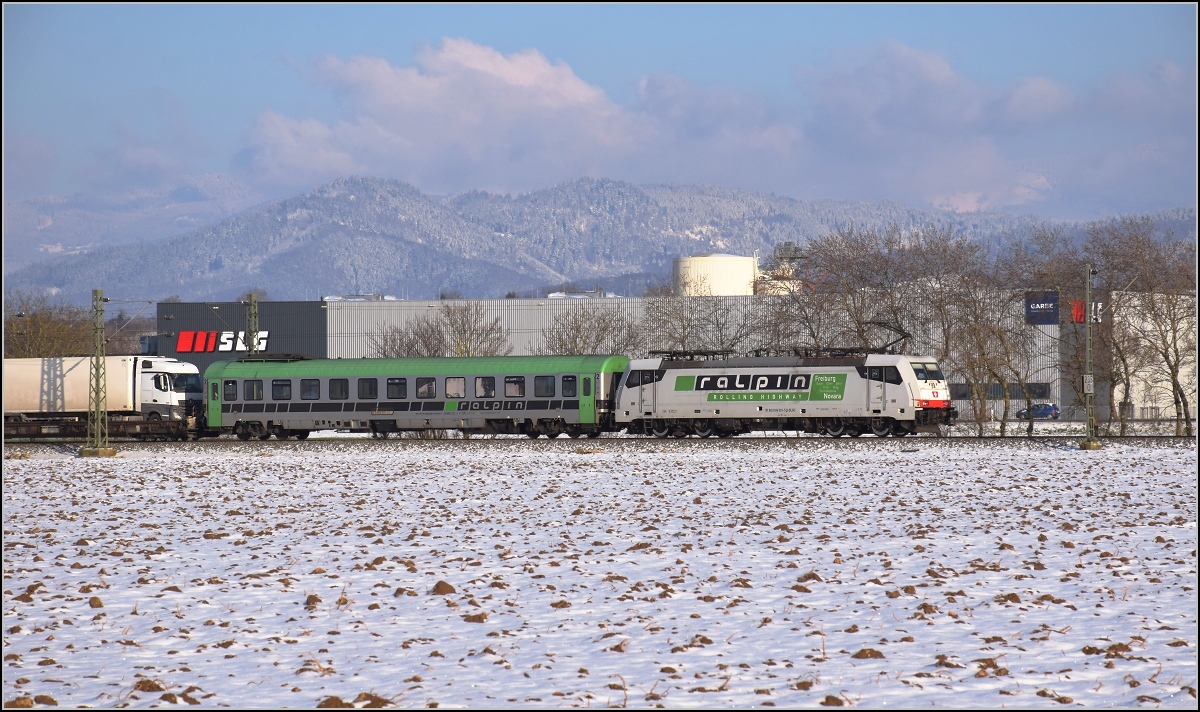 Zwischen Belchensystem und Blauendreieck. 

Richtung Basel mit einer RoLa fährt 186 901 der BLS Cargo in neuem Design. Zuvor war sie eine Crossrail-Lok. Buggingen, Februar 2021.