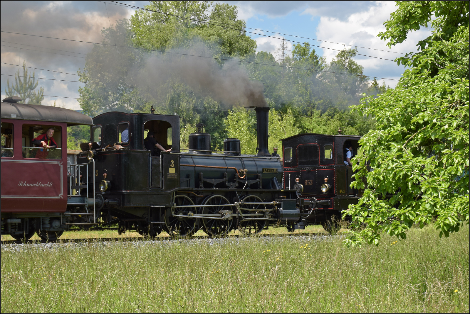 150 Jahre Emmentalbahn. 

E 3/3 853 der Jura-Simplon und Ed 3/3 3 'Langnau' der Emmentalbahn (im Bild) fahren mit ihrem Sonderzug durch einen Obstgarten in den Schwerindustriestandort Gerlafingen ein. Mai 2025.