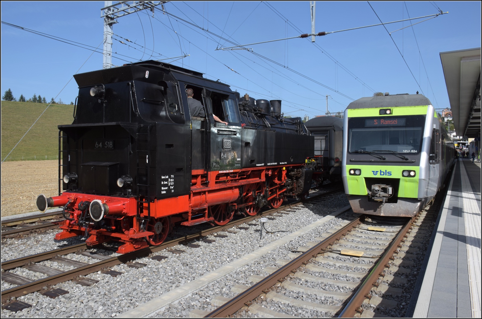 Dampftage Huttwil mit frisch genesenem Bubikopf. 

64 518 rangiert zum Wasserfassen, daneben wartet Nina RABe 525 024 auf Abfahrt. Oktober 2023.