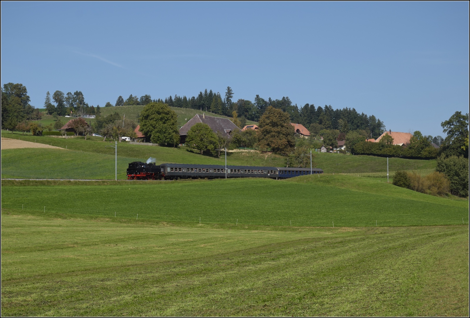 Dampftage Huttwil mit frisch genesenem Bubikopf. 

Was erlaube Olli? Bei Unterbaumen rollt der Zug mit 64 518 nach Sumiswald-Grünen hinunter. Da konnte ich der Versuchung nicht widerstehen und musste mal kurz einen echten Bundesbahnzug draus machen, ganz ohne Präfix  Schweizer . Oktober 2023.
