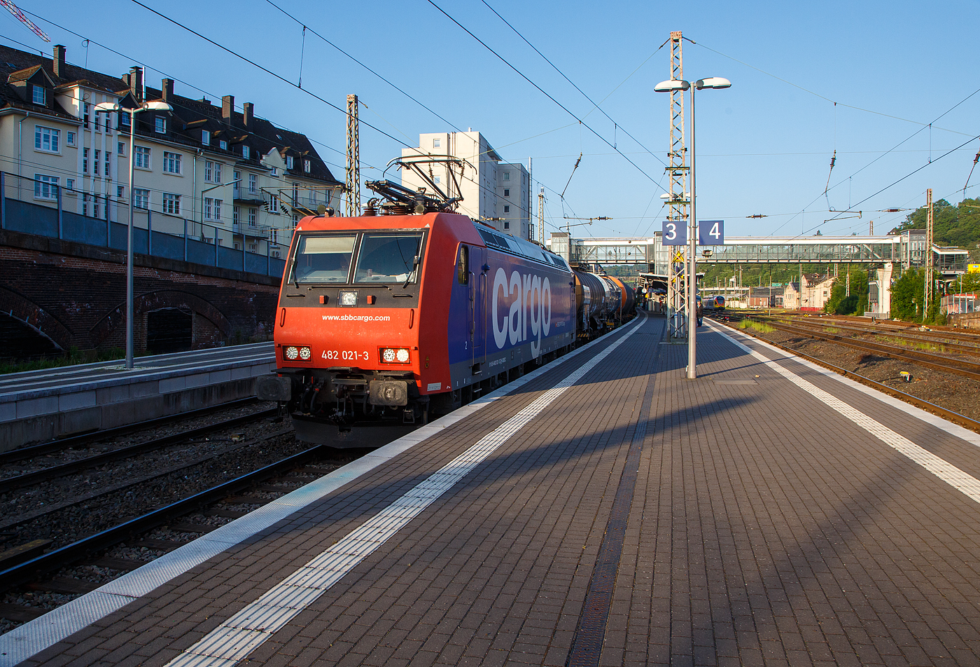 Die an die TX Logistik AG vermietete Re 482 021-3 (91 85 4482 021-3 CH-SBBC) der SBB Cargo AG fährt am 25.Mai 2023, mit einem Kesselwagenzug durch den Hauptbahnhof Siegen in Richtung Dillenburg bzw. Frankfurt.

Die TRAXX F140 AC1 wurde 2003 von Bombardier in Kassel unter der Fabriknummer 33578 gebaut und an die SBB Cargo AG geliefert. Sie hat die Zulassungen für die Schweiz und Deutschland. Die Re 482 wurden aber nicht auf ETSC nachgerüstet, daher sieht diese Loks meist nur in Deutschland. 
