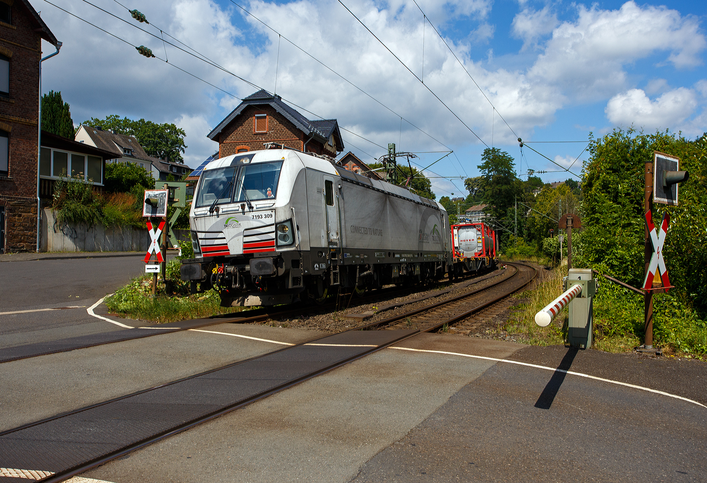 Die TX Logistik AG hat nun auch eigene SIEMENS Vectron, bisher hatte diese nur Loks angemietet. Die recht neue weiße TXL 7193 309 „Connected to Nature“ (91 80 7193 309-0 D-TXL) der TXL - TX Logistik AG (Troisdorf) fährt am 17 Juli 2025, mit einem KLV-Zug, durch Kirchen (Sieg), hier beim Bü km 121,192 in Richtung Betzdorf bzw. Köln.

Nochmals einen lieben Gruß an den netten Lokführer zurück.

Die SIEMENS Vectron MS (X4E) wurde 2024 von Siemens Mobility in München-Allach unter der Fabriknummer 23562 gebaut und am 03.01.2025 an die TXL ausgeliefert. Die mit 6.400 kW konzipierte Mehrsystemlok ist in der Variante A22-11i ausgeführt und hat so die und hat so die Zulassungen und entspr. Länderpakete für Deutschland, Österreich, Schweiz, Italien und die Niederlande (D / A / CH / I / NL).

Über TX Logistik AG
TX Logistik wurde 1999 als privates Eisenbahnverkehrsunternehmen gegründet und bietet mit Verbindungen in elf Ländern ein leistungsfähiges europäisches Netzwerk. Das Unternehmen verfügt über Tochtergesellschaften in der Schweiz, Österreich, Dänemark und Schweden sowie eine lokale Präsenz in Italien. In den Geschäftsbereichen Intermodal und Rail Freight entwickelt TX Logistik umfassende Schienenlösungen für kontinentale und maritime Verkehre sowie maßgeschneiderte Konzepte für konventionelle Fracht. Mit 650 Mitarbeitern und 8,6 Milliarden gefahrenen Tonnenkilometern erwirtschaftete das Unternehmen 2021 einen Jahresumsatz von 253 Millionen Euro. Seit Januar 2017 gehört TX Logistik zu 100 Prozent der Mercitalia Logistics S.p.A., einer Tochtergesellschaft der FS - Ferrovie dello Stato Italiane. Mittlerweile gehört das Unternehmen mit zu den Größten für den Schienengüterverkehr in Europa.

Das Unternehmen bietet den ganzen Umfang an Schienengüterverkehr, inklusive Containertransport und kombiniertem Verkehr an. Wichtigste Transportstrecken sind von den Häfen Hamburg, Bremerhaven, Rotterdam und Antwerpen nach Süddeutschland, Schweiz, Österreich und Italien.

TX Logistik setzt nun auf eigene Vectron Loks:
Anfang Oktober 2024 hat die TX Logistik AG ersten drei von 40 modernen Vectron-Lokomotiven des Herstellers Siemens Mobility aufs Gleis gesetzt, die das zur Mercitalia Logistics (FS Italiane Group) gehörende Schienenlogistikunternehmen im Mai 2023 bestellt hatte. Die Erweiterung der Fahrzeugflotte ist für TX Logistik eine wichtige Voraussetzung, um im intermodalen und grenzüberschreitenden Schienengüterverkehr weiter zu wachsen. Die neuen Lokomotiven werden vor allem auf dem Brenner- und dem Schweiz-Korridor eingesetzt, den strategisch wichtigen Nord-Süd-Achsen in Europa.

Beide Korridore sind stark frequentiert und stellen hohe Anforderungen an die eingesetzten Lokomotiven – von der Zugkraft über die Stabilität bis hin zur grenzüberschreitenden Systemkompatibilität. TX Logistik hat dazu die Maschinen mit verschiedenen Länderpaketen bestellt. 20 Vectron erhalten das Länderpaket für den Betrieb in Deutschland, Österreich, Schweiz, Italien und den Niederlanden (D-A-CH-I-NL) und sollen bis Anfang 2025 übergeben werden. Die Auslieferung der 20 Lokomotiven mit der Ausstattung für den deutsch-österreichisch-italienischen Korridor (D-A-I) soll bis zum Jahresende 2025 erfolgen.

Die Entscheidung für den Kauf der Vectron-Lokomotiven unterstreicht zugleich das Bestreben von TX Logistik, Schienengüterverkehre als umweltfreundliche und effiziente Alternative zum Straßentransport weiter voranzutreiben. Um dies zu unterstreichen und gleichzeitig für den Einstieg in den intermodalen Transport zu werben, hat die erste der drei Vectrons, die im Zughotel in Braunschweig übergeben wurden, eine spezielle Lok-Beklebung mit dem Schriftzug „Start now (Nature). Driven by Green Passion“ erhalten.

Die neuen Loks bieten mit ihrer Flexibilität und Leistungsfähigkeit ideale technische Voraussetzungen, um den steigenden Anforderungen des europäischen Güterverkehrs gerecht zu werden. Mit der modernen Vectron-Flotte, so TX Logistik, sei man mittelfristig nun in der Lage, die Kapazitäten auf dem Brenner- und dem Schweiz-Korridor deutlich zu erhöhen sowie die Effizienz und Zuverlässigkeit im Schienengüterverkehr weiter zu verbessern.
