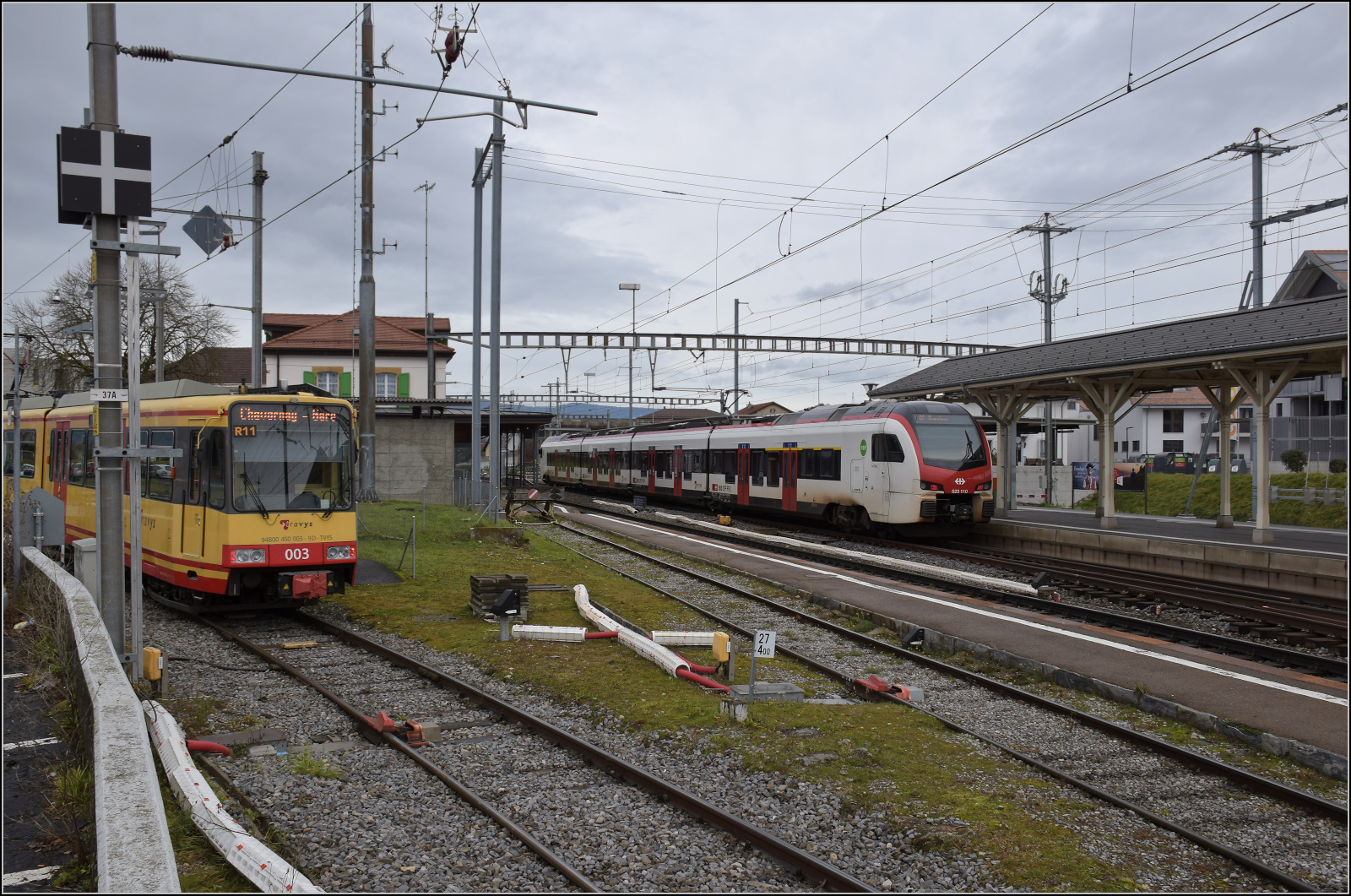 Ende einer Ära - der Gleichstrom und die  Lokalbahn  gehen. 

Die Karlsruher Zweisystem-Strassenbahn  Be 4/8 003  alias 94 800 450 003-9 D-TVYS passt gerade so eben in den OC-Bahnsteig in Chavornay. Dahinter steht schon die Zukunft dieser Bahn bereits am SBB-Bahnsteig bereit. Künftig wird die Strecke erst nach dem Bahnhof ausgefädelt, so dass eine Durchbindung bis Orbe möglich ist. Dafür ist eine Bauzeit von einem Jahr vorgesehen. Dezember 2025.