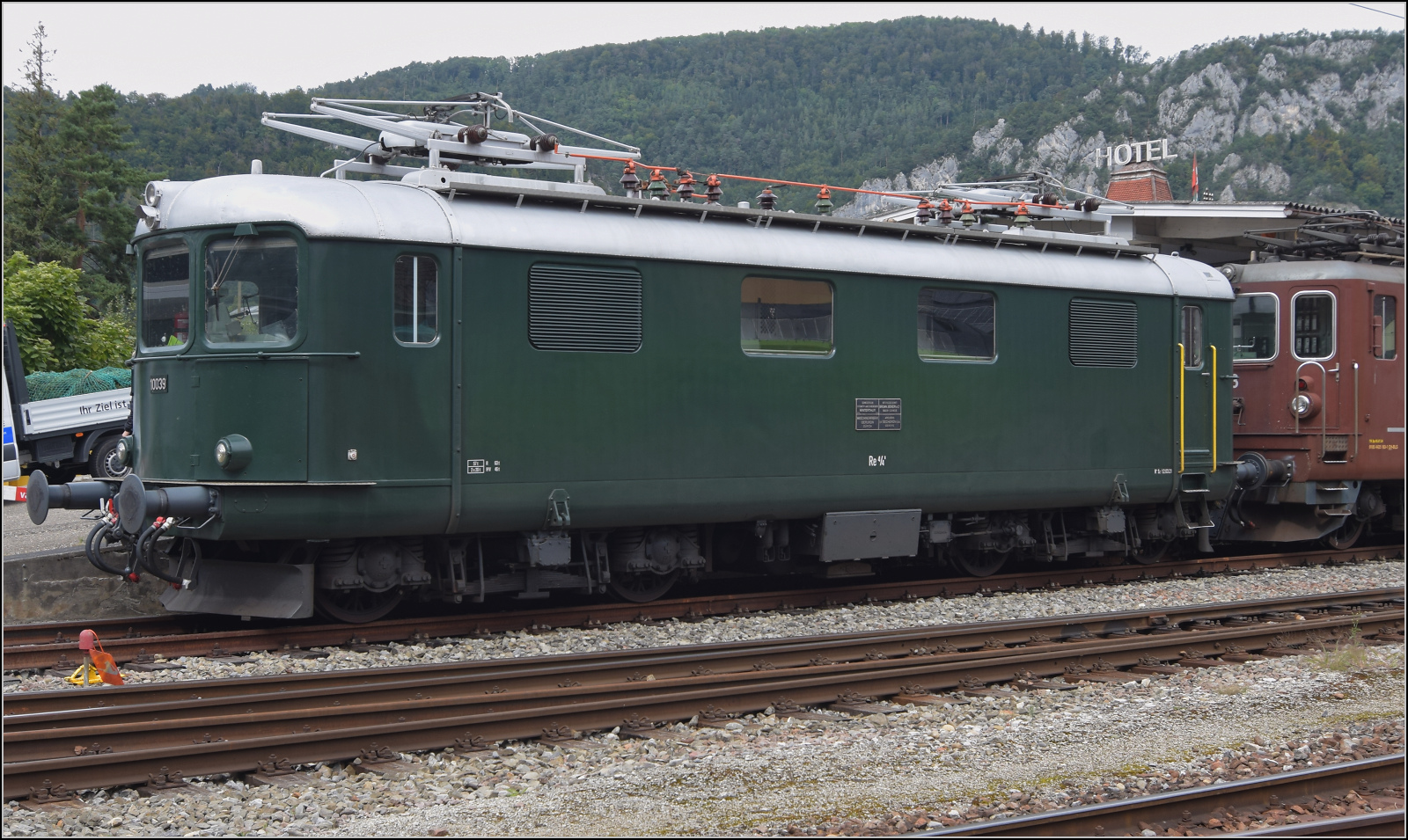 Grosses BoBo-Treffen in Balsthal - die Teilnehmerinnen:

Im Gegensatz zu den Ae 4/4 der BLS suchte man bei den SBB Geschwindigkeit im kurvenreichen Netz. Mit höheren Kurvengeschwindigkeiten konnte man die eine oder andere Minute aus den Fahrplänen herauskitzeln. Die Roten Pfeile der SBB hatten es vorgemacht, mit den Gepäcktriebwagen RFe 4/4 konnten nunmehr auch Wagenzüge schnell befördert werden, aber bei geringer Leistung. So entstanden die sehr leichten Schnellzugloks Re 4/4. Wegen des geringen Gewichts fehlte aber weiterhin Zugkraft und nötige Leistung. Konsequenterweise führte die Entwicklung weiter zu höherer Leistung und mehr Gewicht, sprich den bei der Veranstaltung gefeierten Re 4/4 II. In diesem Zuge wurden die Re 4/4 zu Re 4/4 I. Von deren zwei dennoch recht unterschiedlichen Serien nahm Re 4/4 I 10039 aus der 2. Serie an der Veranstaltung teil. Äussere Klus, September 2024.