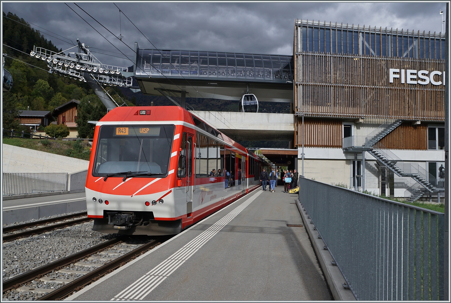 In Fiesch wurde der Bahnhof einige Hundert Meter weiter nach Osten versetzt und befindet sich nun direkt bei der der Luftseilbahn, was das Umsteigen sehr erleichtert. Da man wie solchen Bauten sehr grosszügig Beton verwendet, fehlt dem neuen Bahnhof von Fiesch jeder Ansatz einer gemütlichen Landstation und man ist froh, in den Zug einzusteigen und wegzufahren, selbst mit einem  Komet . 

19. Oktober 2023